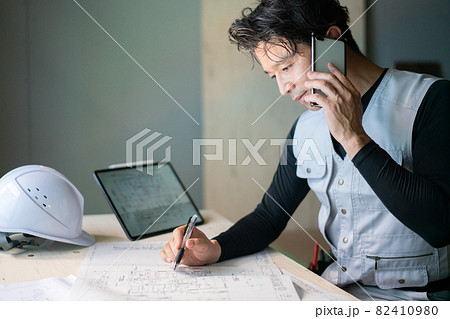 図面を確認する作業員の男性 82410980