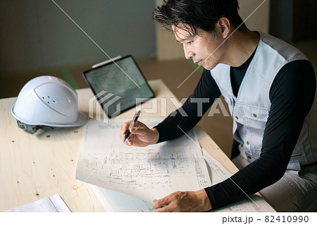図面を確認する作業員の男性 82410990