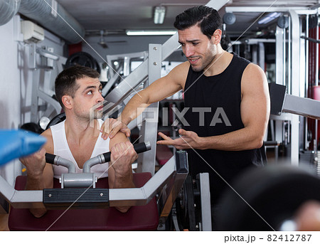 Man during training with instructor in gym 82412787