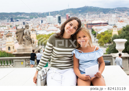 Young woman tourist hugs with daughter in the city center Young woman tourist hugs with daughter in the city center 82413119