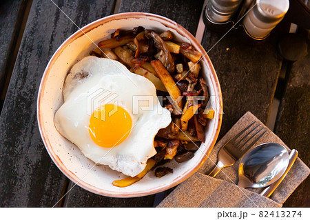 Fried eggs served with roasted potatoes with mushrooms Fried eggs served with roasted potatoes with mushrooms 82413274