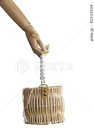 Fashion handmade rattan bag in wood puppet hand, Isolated on white Fashion handmade rattan bag in wood puppet hand, Isolated on white 82414504