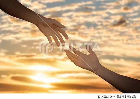 Giving a help hand concept. Reaching hand helping, hope and support each other over sunset 82414829