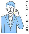スマホで話す、スーツを着た若い男性の上半身（色付き） 82417521