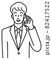 スマホで話す、スーツを着た若い男性の上半身（線） 82417522