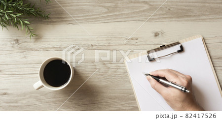テーブルの上の資料にメモを書いている人 82417526