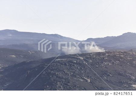 Helicopters over a landscape burned by a forest fire, finishing putting it out 82417651