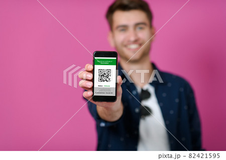 covid passport a young man shows his qr code and covid19 passport on his cell phone 82421595