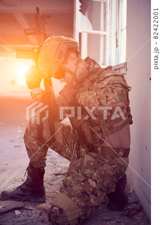 soldier in action near window changing magazine and take cover 82422001