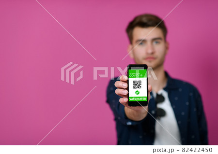 covid passport a young man shows his qr code and covid19 passport on his cell phone covid passport a young man shows his qr code and covid19 passport on his cell phone 82422450