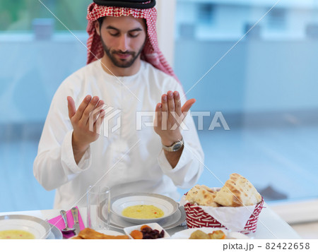 Muslim man making iftar dua to break fasting during Ramadan 82422658