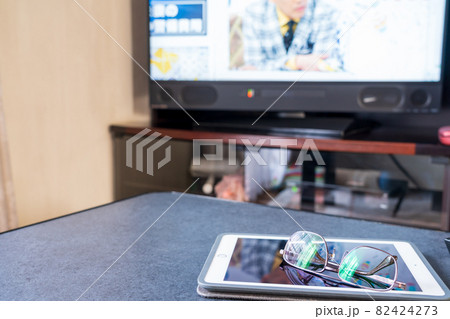 テレビのワイドショーを見る タブレットと遠近両用メガネ テレビのワイドショーを見る タブレットと遠近両用メガネ 82424273