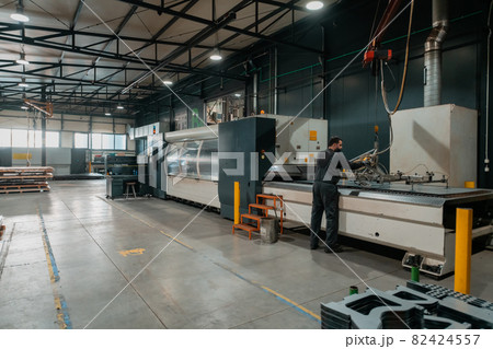 A smart factory worker or engineer wears a face mask because of a pandemic and makes machines in a production workshop. The concept of industry and engineering. 82424557