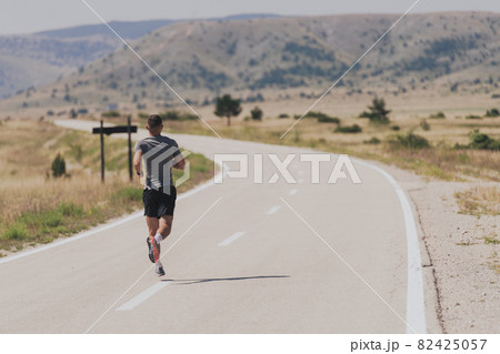 Young man and woman in protective masks running and doing exercises outdoors in the morning. Sport, Active life Jogging during quarantine. Covid-19 new normal. High quality photo. Selective focus. Young man and woman in protective masks running and doing exercises outdoors in the morning. Sport, Active life Jogging during quarantine. Covid-19 new normal. High quality photo. Selective focus. 82425057