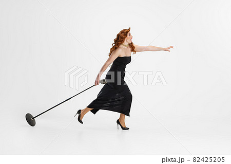 Side view full-length portrait of female singer carrying microphone and running away isolated over white background Side view full-length portrait of female singer carrying microphone and running away isolated over white background 82425205