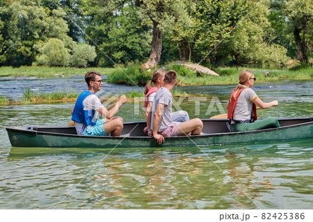Group adventurous explorer friends are canoeing in a wild river 82425386