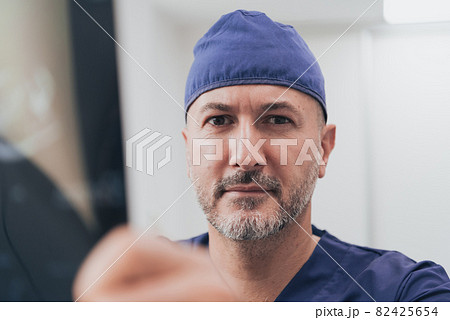 Orthopedist doctor examining X-ray picture in hospital or clinic Orthopedist doctor examining X-ray picture in hospital or clinic 82425654