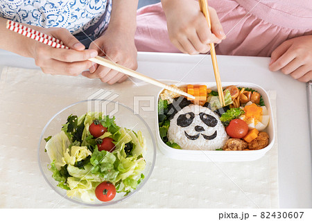 キャラ弁のお弁当を作るお母さんと子供の手のアップ 82430607