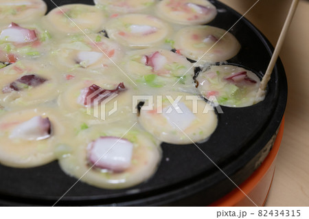 たこ焼き器でたこ焼きを作っている様子 82434315