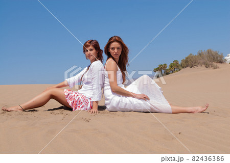 women in white dress in desert dunes  82436386
