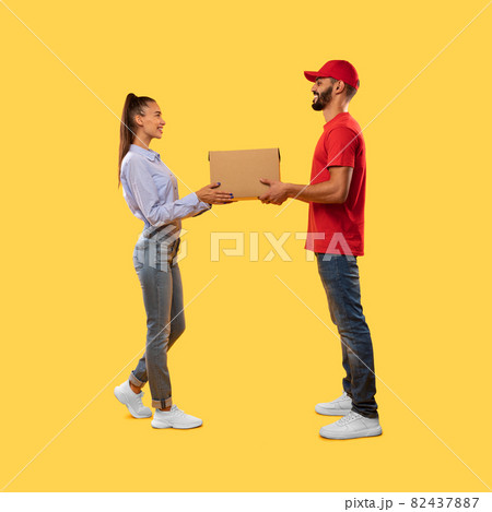 Courier Guy In Uniform Giving Box To Lady, Yellow Background 82437887