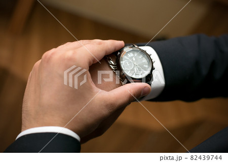 A man looks at his wristwatch afraid of being late for a date 82439744