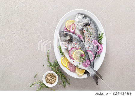 Fresh whole dorada fish and ingredients for cooking. Raw sea bream with spices on white background. Healthy food, diet. Top view with copy space. 82443463