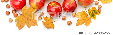 Autumn apples,hazelnuts and leaves isolated on white . Wide photo. 82445255