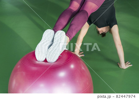 Woman at the gym doing exercises with her legs on pilates ball Woman at the gym doing exercises with her legs on pilates ball 82447974