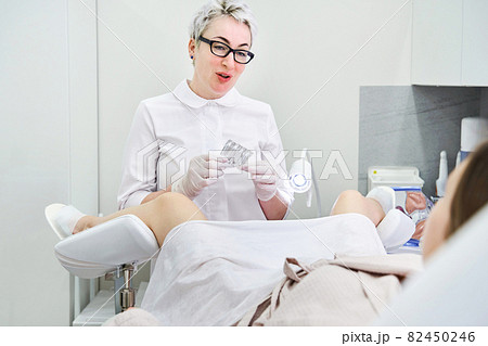 Doctor wearing medical gloves holding a pack of rectal or vaginal suppositories 82450246