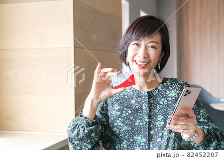 スマホ手に取り家族カードもつ女性 スマホ手に取り家族カードもつ女性 82452207