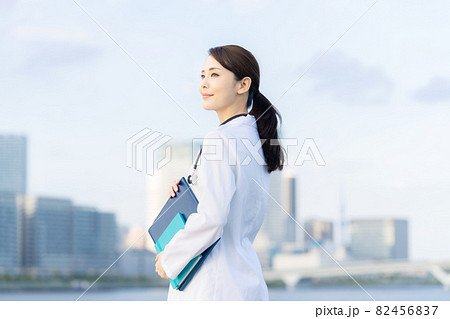 都市の前に立つ白衣の女性　医師　科学者 82456837