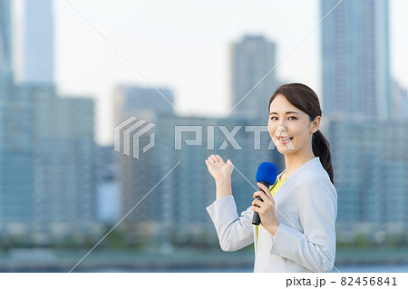 都市の前に立つ女性アナウンサー 82456841