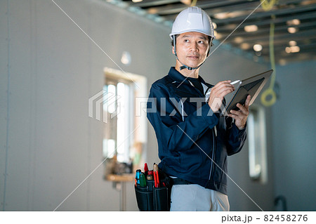 タブレットを見る作業員の男性 82458276
