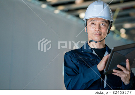 タブレットを見る作業員の男性 82458277