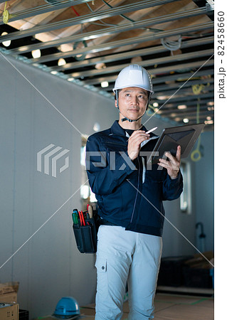 タブレットを見る作業員の男性 82458660