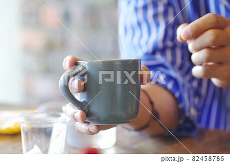 マグカップで飲み物を飲む男性 82458786