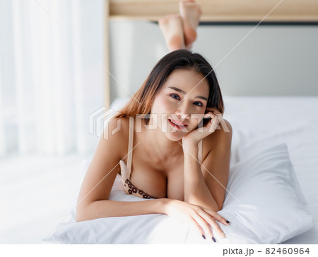 Beautiful young naughty Asian girl with sexy bra enjoy lie down with pillow on white bed and impassioned smile for bright morning of rest day. Beautiful young naughty Asian girl with sexy bra enjoy lie down with pillow on white bed and impassioned smile for bright morning of rest day. 82460964