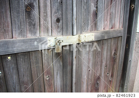 古い木製の扉の閂に付けられた錠前 82461923