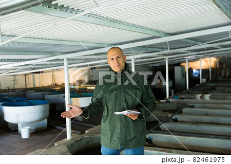 Farmer demonstrating trout farm Farmer demonstrating trout farm 82461975
