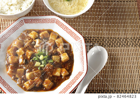 お豆腐がたくさん入っている熱々四川風麻婆豆腐とライスとタマゴスープとレンゲを俯瞰で撮影 82464823