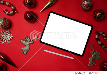 Red and gold Christmas decoration ball and digital tablet on red background. Christmas and New year concept. 82465808