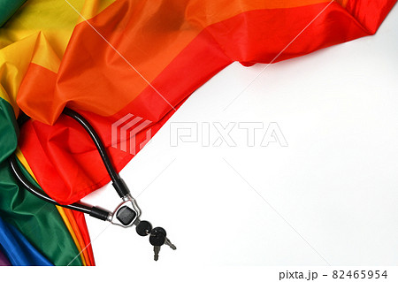 Rainbow flag of fabric texture for LGBT with metal chain and padlock on white background. Love and freedom concept. Rainbow flag of fabric texture for LGBT with metal chain and padlock on white background. Love and freedom concept. 82465954