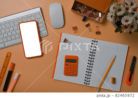 Mock up smart phone, notebook, calculator and stationery on brown background. Mock up smart phone, notebook, calculator and stationery on brown background. 82465972