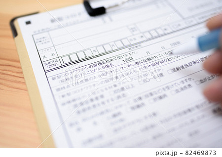 コロナウイルスワクチン接種　予診票の記入　新型コロナワクチン接種の予約　記入する男性 82469873