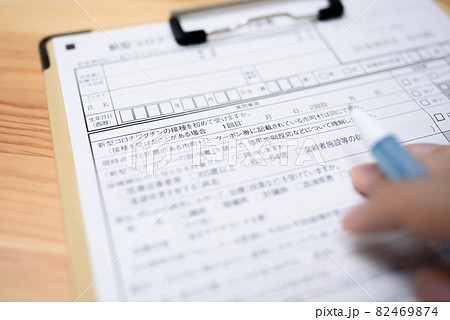 コロナウイルスワクチン接種　予診票の記入　新型コロナワクチン接種の予約　記入する男性 82469874