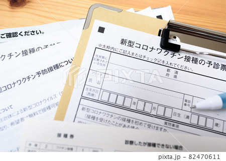 コロナウイルスワクチン接種　予診票と接種券　新型コロナワクチン接種　予診票にクリップボードで記入 82470611