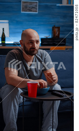 Relax man spending free time watching TV eating popcorn 82471008