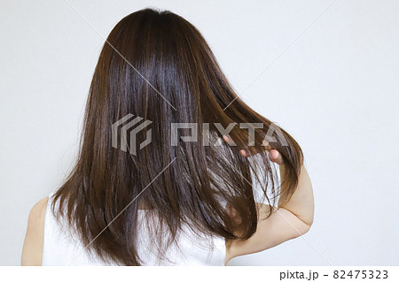 髪の毛を触る女性の後ろ姿 82475323