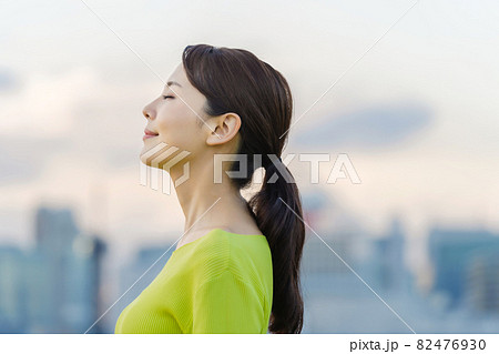都市の前で目を閉じる女性 82476930